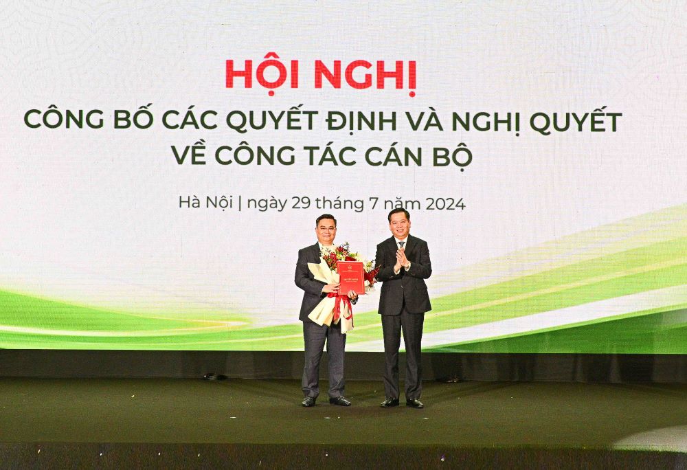 Đồng chí Nguyễn Long Hải - Ủy viên dự khuyết BCH Trung ương Đảng, Bí thư Đảng ủy Khối DNTW (bên phải) trao Quyết định và tặng hoa chúc mừng Đồng chí Nguyễn Thanh Tùng, tân Bí thư Đảng ủy Vietcombank. Ảnh: Vietcombank.