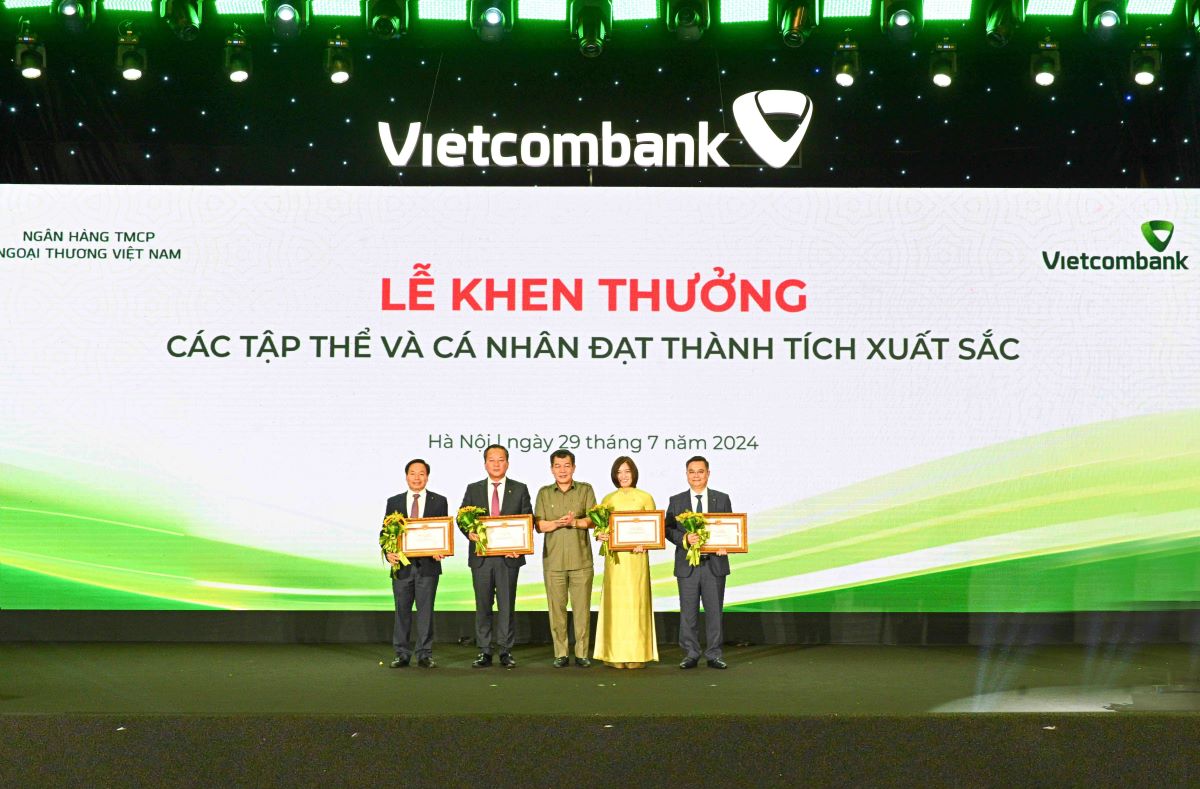 Đồng chí Nguyễn Đức Phong - Phó Bí thư thường trực Đảng ủy Khối DNTW (đứng giữa) trao Bằng khen và tặng hoa cho 4 đảng viên vinh dự nhận Bằng khen của Đảng ủy Khối DNTW. Ảnh: Vietcombank.