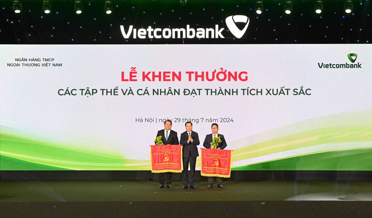 Đồng chí Nguyễn Long Hải - Ủy viên dự khuyết BCH Trung ương Đảng, Bí thư Đảng ủy Khối DNTW (đứng giữa) trao Cờ và tặng hoa cho 2 đảng bộ vinh dự nhận Cờ của Đảng ủy Khối DNTW. Ảnh: Vietcombank.